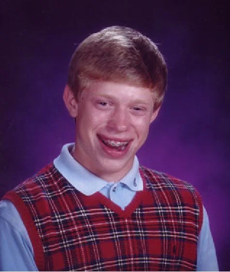 Bad Luck Brian meme template: a smiling teenage boy in a plaid sweater vest and braces posing for a school photo