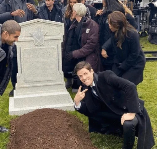 Grant Gustin Over Grave meme template: the Flash actor crouching beside a prop gravestone flashing a peace sign