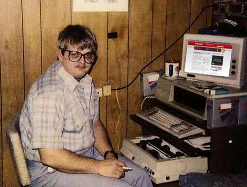 Man with glasses sitting next to a vintage computer setup meme template