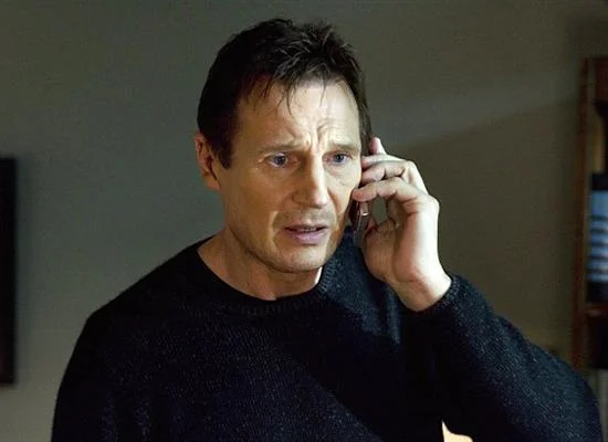 Liam Neeson holding flip phone with intense stare from Taken meme template