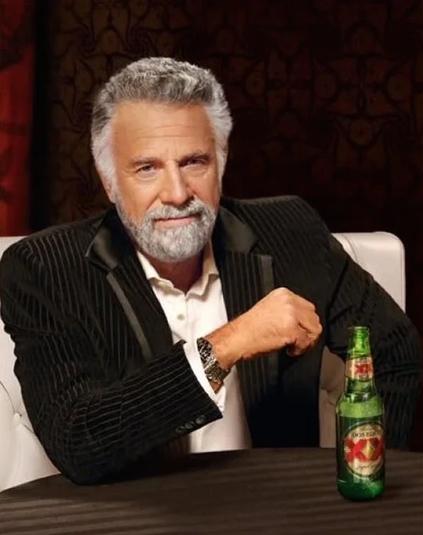 The Most Interesting Man in the World meme template: a bearded man with a beer at a table